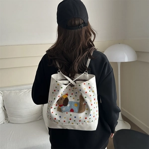 Chic white tote backpack with colorful polka dots and cute dog patch on a female model