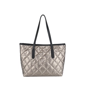 Sac fourre-tout matelassé métallisé couleur champagne avec anses en cuir noir sur fond blanc