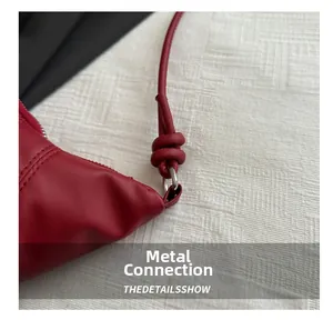 Detailed macro view of dark red leather bag with silver metal ring and knotted strap