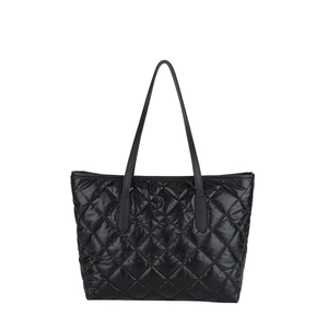 Grand sac cabas noir matelassé avec anses en cuir sur un fond blanc épuré