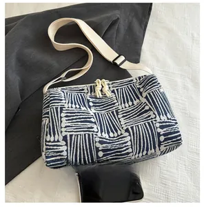 Detail view of blue and white geometric striped tote bag with wide strap and zip knots