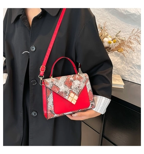 Modieuze rode handtas met slangenpatroon gedragen door model voor een stijlvolle look
