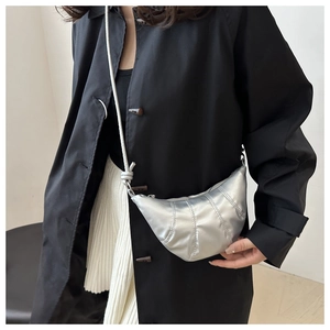 Silver croissant bag in metallic finish with quilted design shown on model for daily wear