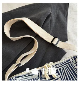 Detail of woven blue and white striped canvas tote with white nylon strap and resin buckle