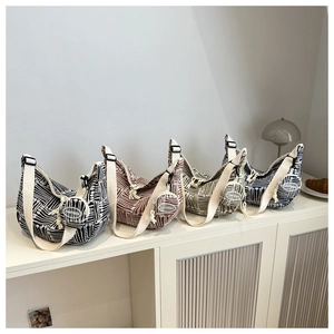 Detailed view of striped canvas half-moon bags with matching round coin purses