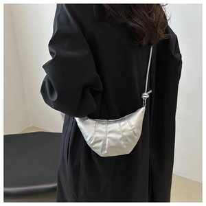 Sac argenté métallisé avec matelassage vertical et bandoulière nouée sur mannequin