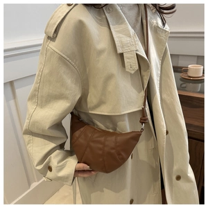 Minimalist brown croissant shoulder bag styled with a stylish beige trench coat outfit