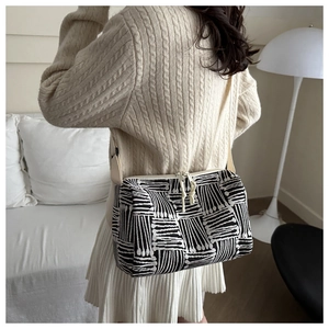 Detail of geometric jacquard crossbody bag with dual knot zippers and adjustable strap
