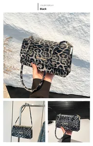 Detail view of leopard print baguette bag with golden buckle and sleek shoulder strap