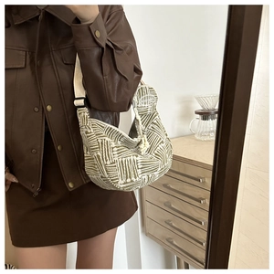 Detail of green geometric jacquard hobo bag with wide adjustable strap and knot zipper pull