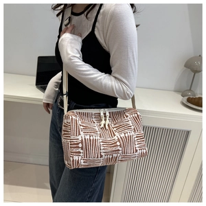 Detail of striped canvas tote bag with adjustable strap in a modern minimalist setting