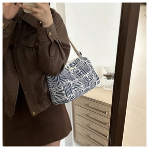 Detail view of large striped tote bag with woven texture in a casual lifestyle setting