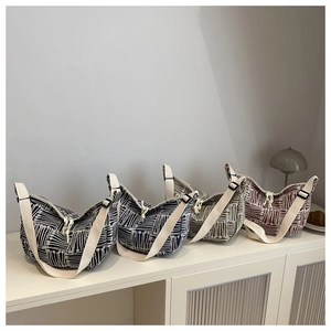 Detailed row of striped canvas hobo bags showing four colors on a minimalist shelf