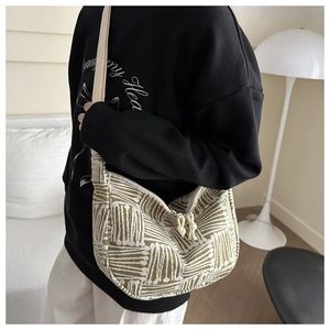 Close-up of green geometric striped canvas tote bag with adjustable strap and drawstring