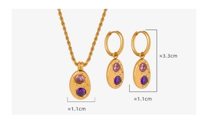 Détail du collier chaîne torsadée dorée et des boucles d'oreilles avec zircons violets