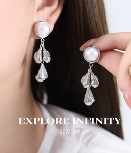 Detailed close-up of a silver baroque pearl earring with irregular metallic drops