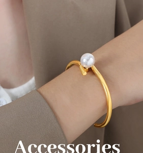 Bracelet jonc ouvert en acier titane doré poli avec perle blanche sur un mannequin