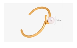 Détail d'un bracelet en acier titane doré avec une perle de 1,2 cm au design épuré