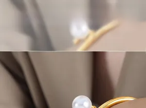 Détail d'un bracelet en acier titane plaqué or orné d'une perle d'eau douce blanche