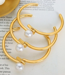 Vue détaillée de trois joncs plaqués or avec accents de perles d'eau douce blanches