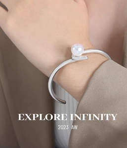 Bracelet jonc ouvert en acier titane argenté avec perle porté sur un mannequin