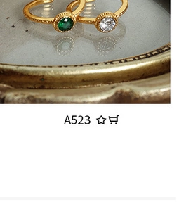 Detail of adjustable gold-plated vintage rings with emerald and zircon stones