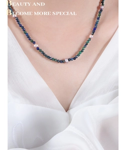 Detail of necklace with faceted lapis lazuli beads and pink freshwater pearls on a model