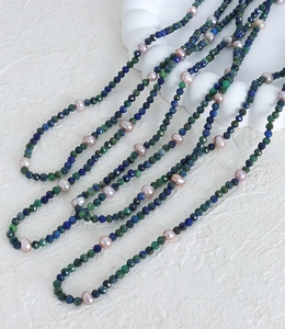 Detail of long beaded necklace with blue natural stone and purple freshwater pearls