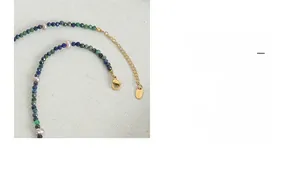 Detail of lapis lazuli and freshwater pearl necklace with golden clasp and metal tag