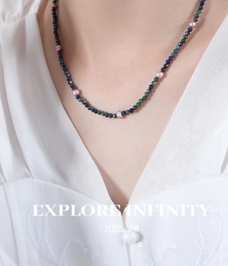 Close-up of handmade necklace featuring faceted lapis lazuli beads and purple pearls