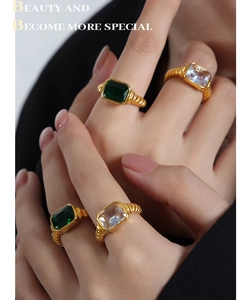 Detail von 18k vergoldeten Punk-Ringen mit smaragdgrünen und weißen Steinen