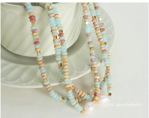 Macro shot of bohemian beads and large white baroque pearls on a white ceramic bowl