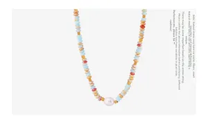 Detail of colorful natural stones and a freshwater pearl necklace with golden metal beads