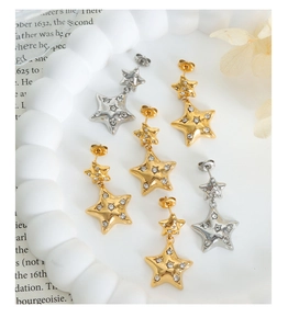 Close-up of three pairs of layered star earrings with micro-inlaid zircons on a tray
