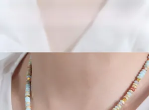 Macro detail of bohemian necklace featuring colorful natural stones and pearls on a model