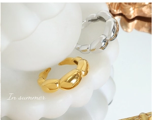 Macro detail of bubble-shaped gold and silver open rings with high-polished metallic finish