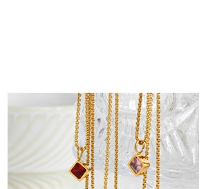 Detailed close-up of square cut red and pink crystal necklaces with golden chains