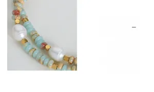 Detailed close-up of mixed natural stone beads and baroque pearl necklace with golden spacers