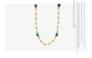 Dettaglio della collana di perle naturali e pietre preziose verdi su sfondo bianco