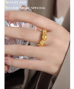 Close-up of a chunky 18k gold plated stainless steel ring with a smooth oval chain design
