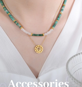 Macro shot of gold Fu pendant with double-layered green and white bead necklace