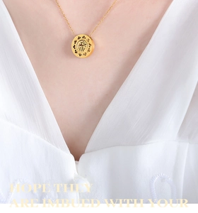 Macro view of gold-plated hollow Fu pendant necklace on model's neck for elegant look
