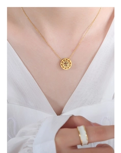 Detail of 18k gold plated necklace with Fu character pendant and bicolor minimalist ring