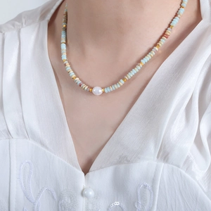 Colorful natural stone and freshwater pearl beaded necklace worn on a woman's neck