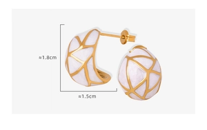 Détail des boucles d'oreilles en titane doré en forme de C avec émail blanc et texture