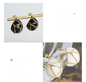 Détail macro de boucles d'oreilles vintage en forme de C avec émail noir et blanc