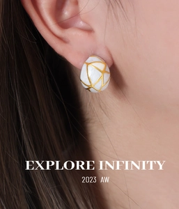 Détail de boucles d'oreilles dôme en émail blanc avec grille dorée sur mannequin