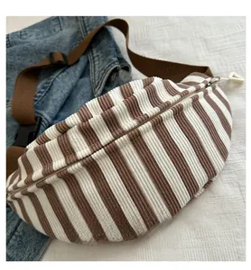 Detailed view of striped corduroy chest bag with adjustable strap and plastic buckle