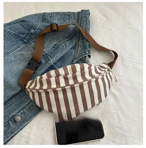 Detailed comparison of vintage striped chest bag size with a smartphone on denim