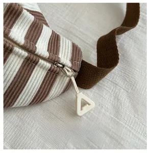 Detailed close-up of brown striped corduroy texture with durable metal zipper and strap